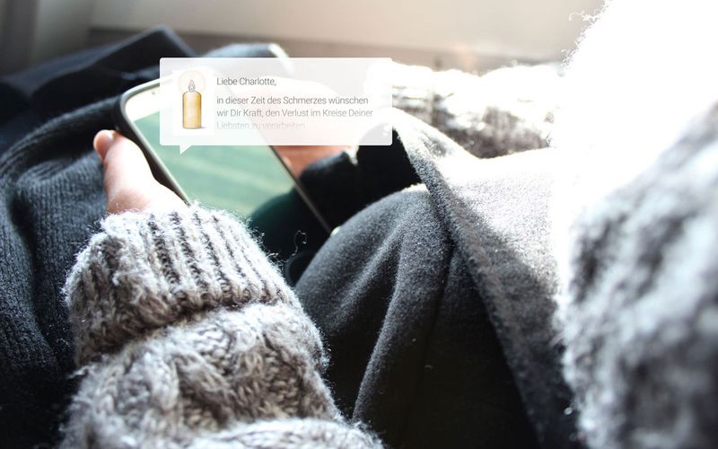 Angehörige liest Kondolenzen im Nitschke Gedenkportal auf dem Smartphone nach